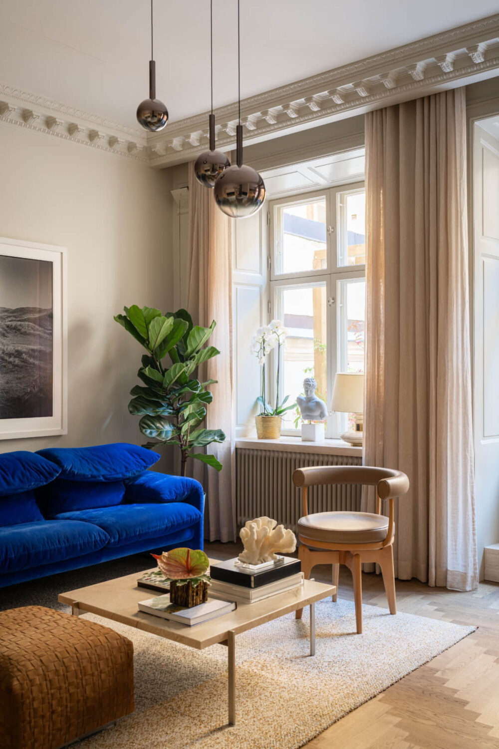 Hotel-Style Interiors in a Late 19th Century Apartment in Stockholm 4 living room blue sofa period details gray walls