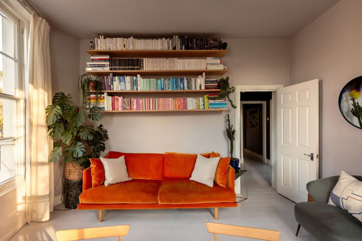A Corner Apartment with Large Windows in a Former London Pub 2 living room orange sofa bookshelves
