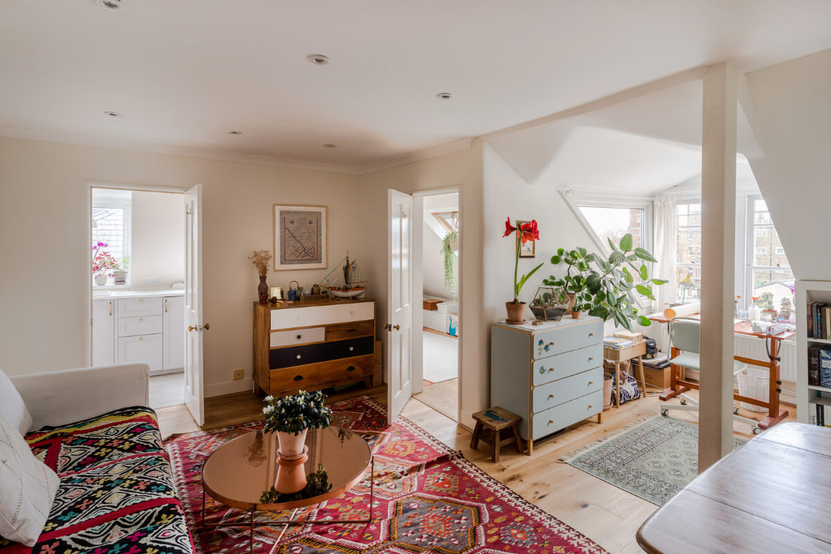 A Light-Filled London Attic Apartment with Cozy Nooks 1 living room slanted ceiling colorful textiles dormer window