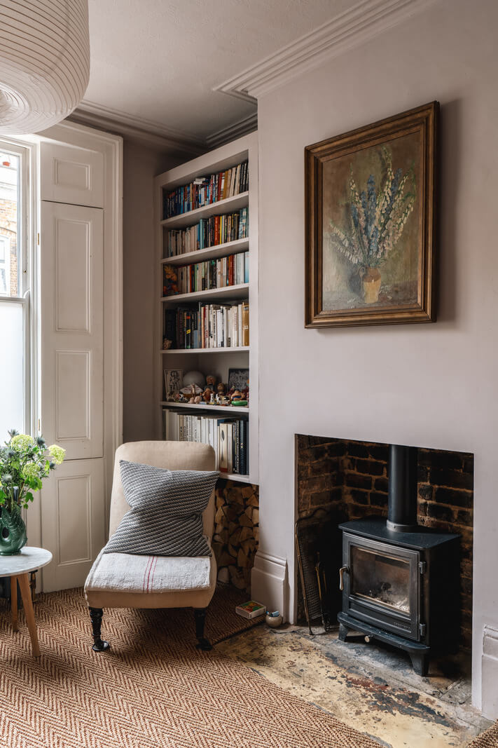 A Cozy Victorian Home Painted in Moody Blue and Gray Tones 4 log burner and bookshelves gray living room
