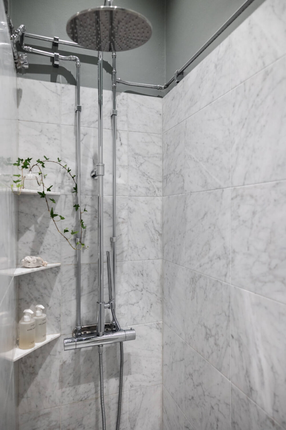 A Luxurious Stockholm Apartment with Period Features and a Blue Fireplace 17 marble tiled shower small corner shelves