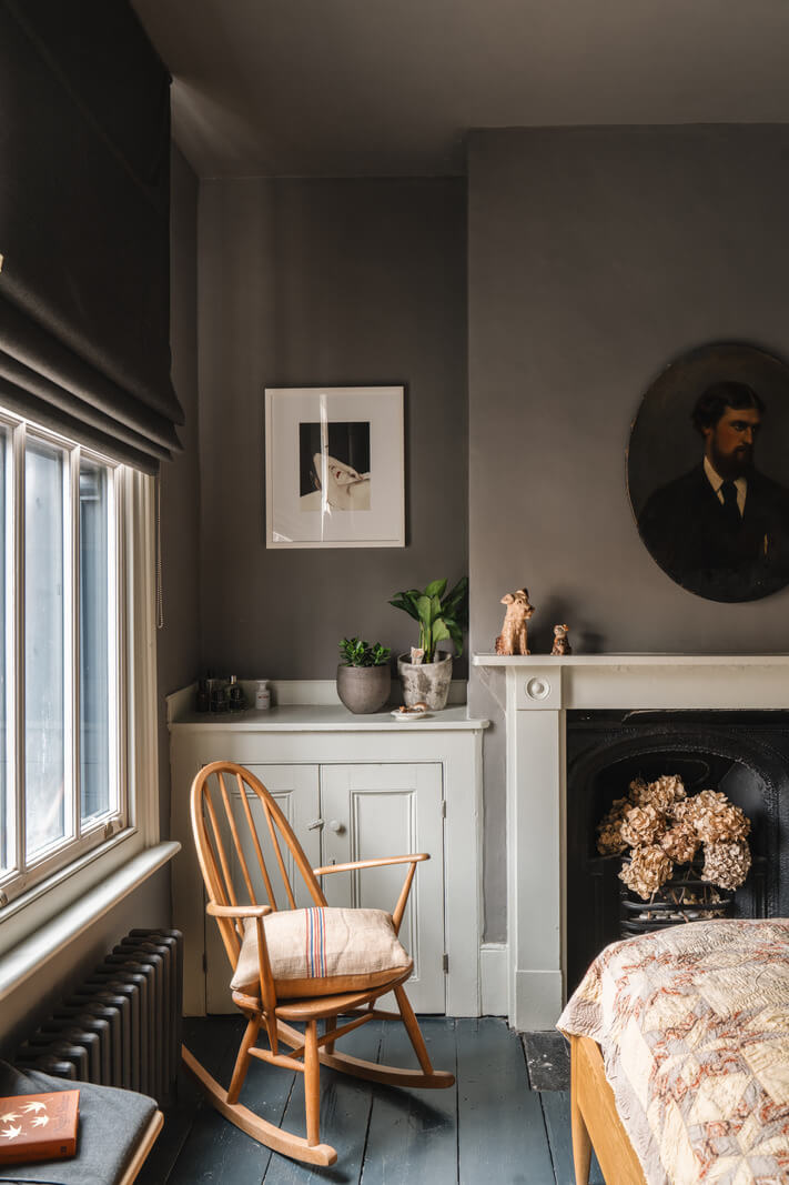 A Cozy Victorian Home Painted in Moody Blue and Gray Tones 17 moody bedroom with painted floorboards and fireplace