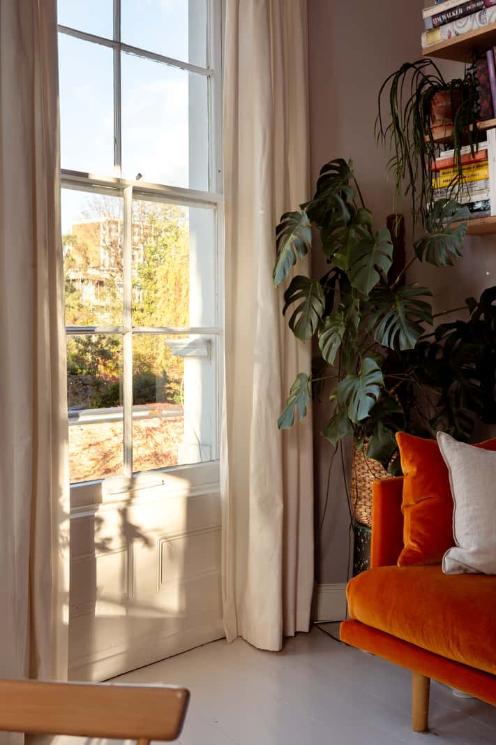 A Corner Apartment with Large Windows in a Former London Pub 3 orange sofa gray painted floorboards large window