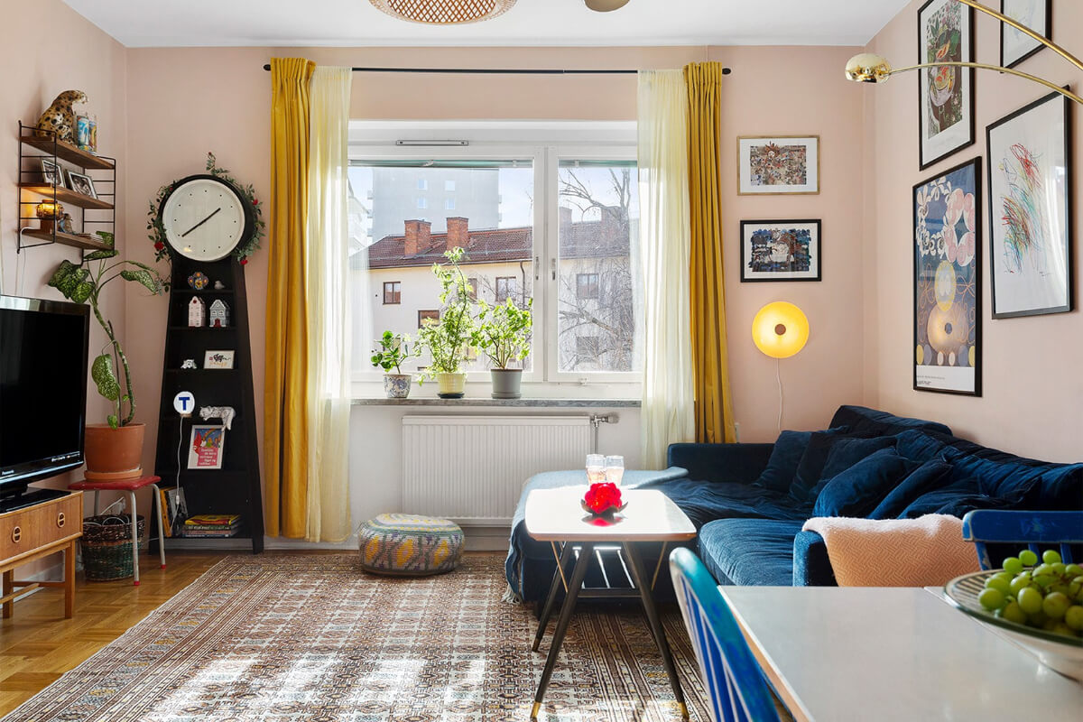 A Colorful 1940s Apartment in Stockholm 1 pink living room yellow curtains blue velvet sofa