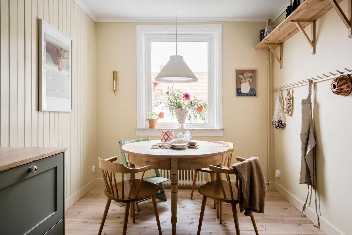 Timeless Charm and Contemporary Design in a 1930s Duplex Apartment 9 round wooden dining table shelves yellow walls