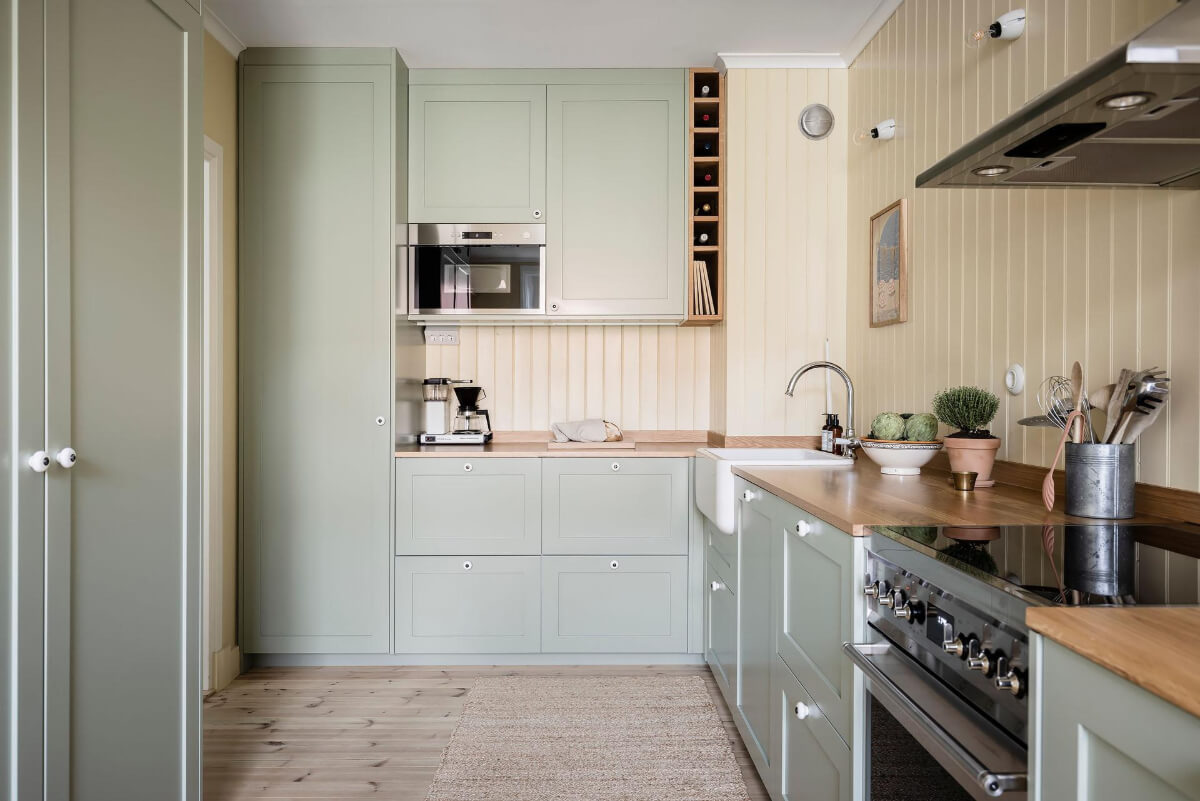Timeless Charm and Contemporary Design in a 1930s Duplex Apartment 12 scandi kitchen green cupboards yellow walls