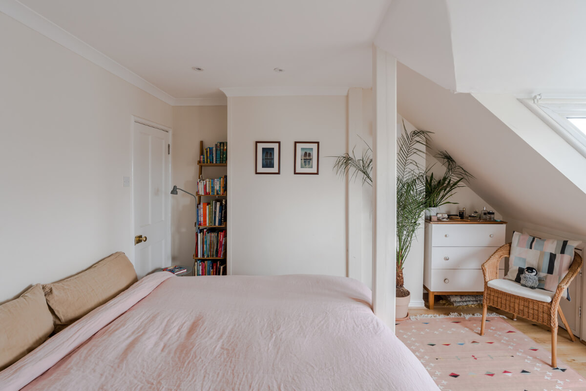 A Light-Filled London Attic Apartment with Cozy Nooks 17 serene bedroom pink rug slanted ceiling