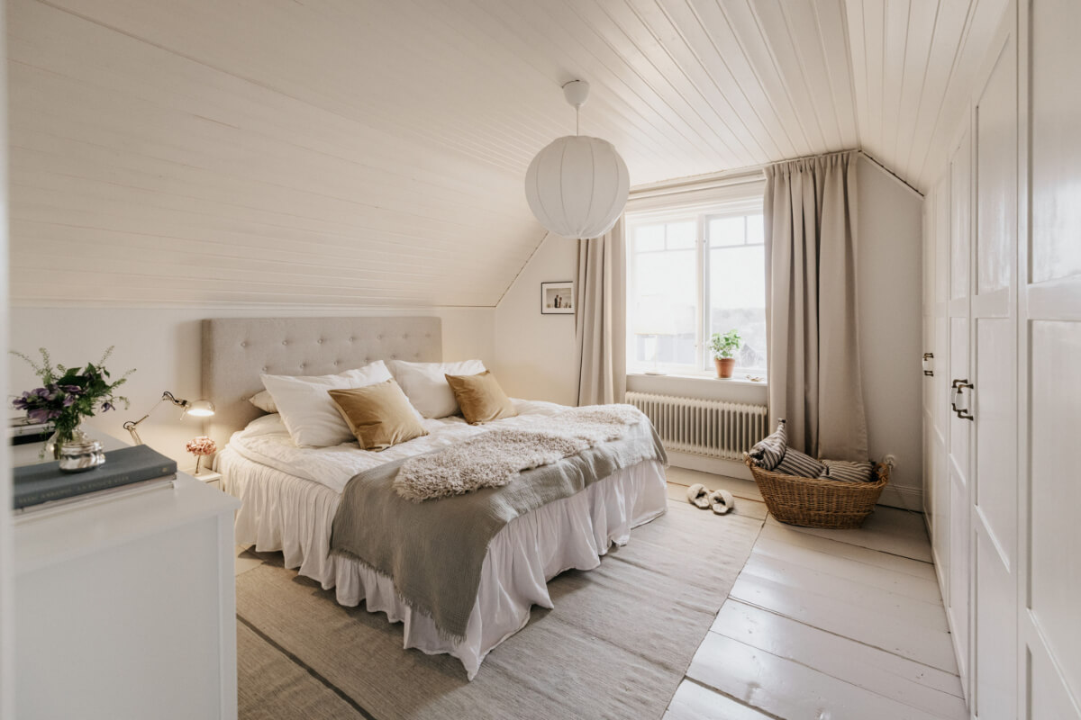 Light-Filled Rooms in a Charming 1907 Swedish Villa 23 serene master bedroom wooden floorboards slanted ceiling