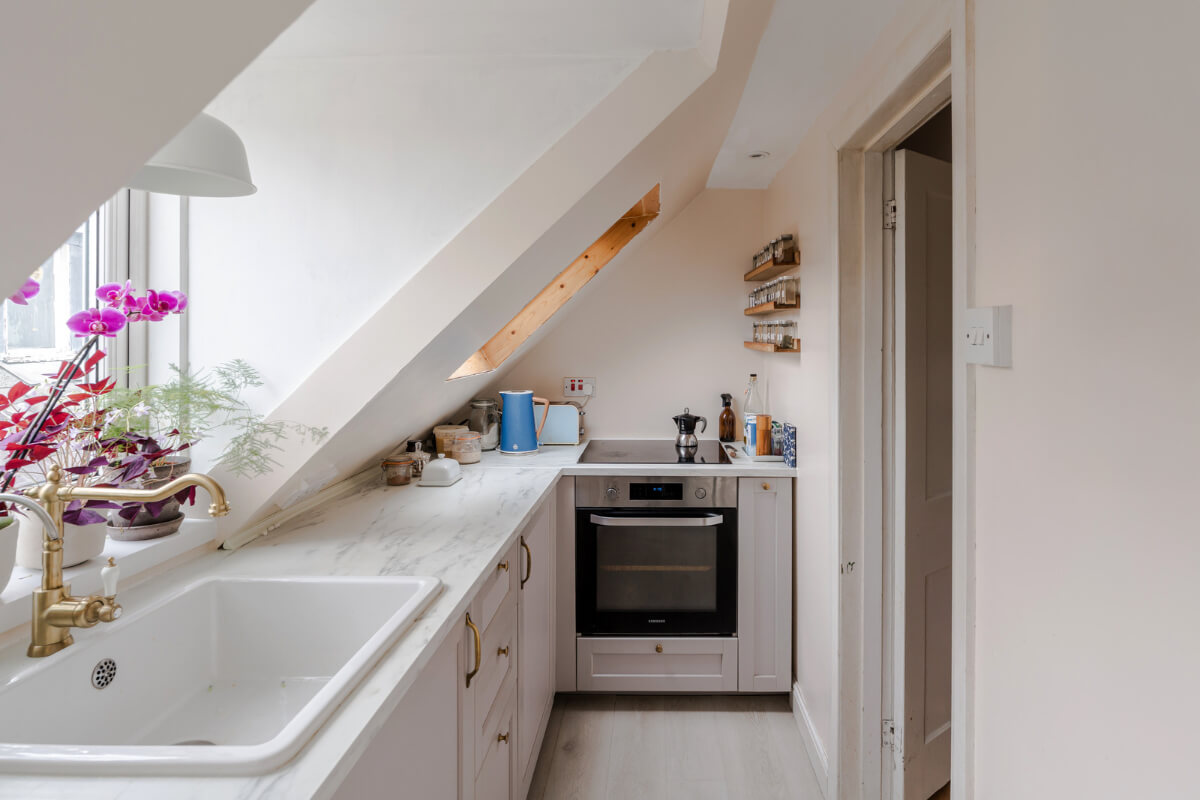 A Light-Filled London Attic Apartment with Cozy Nooks 16 small white kitchen slanted ceiling brass fittings