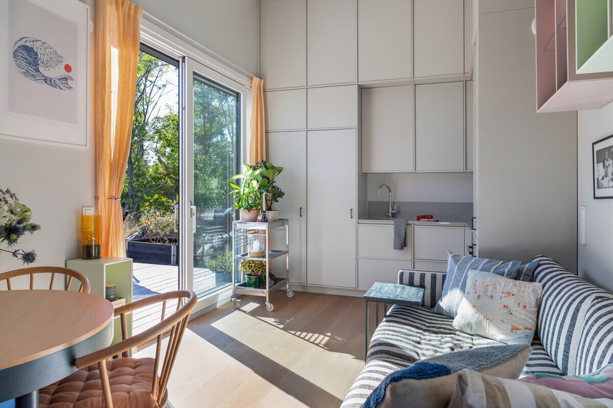 A Modern Tiny House in the Swedish Archipelago 2 tiny house high ceilings striped sofa kitchen