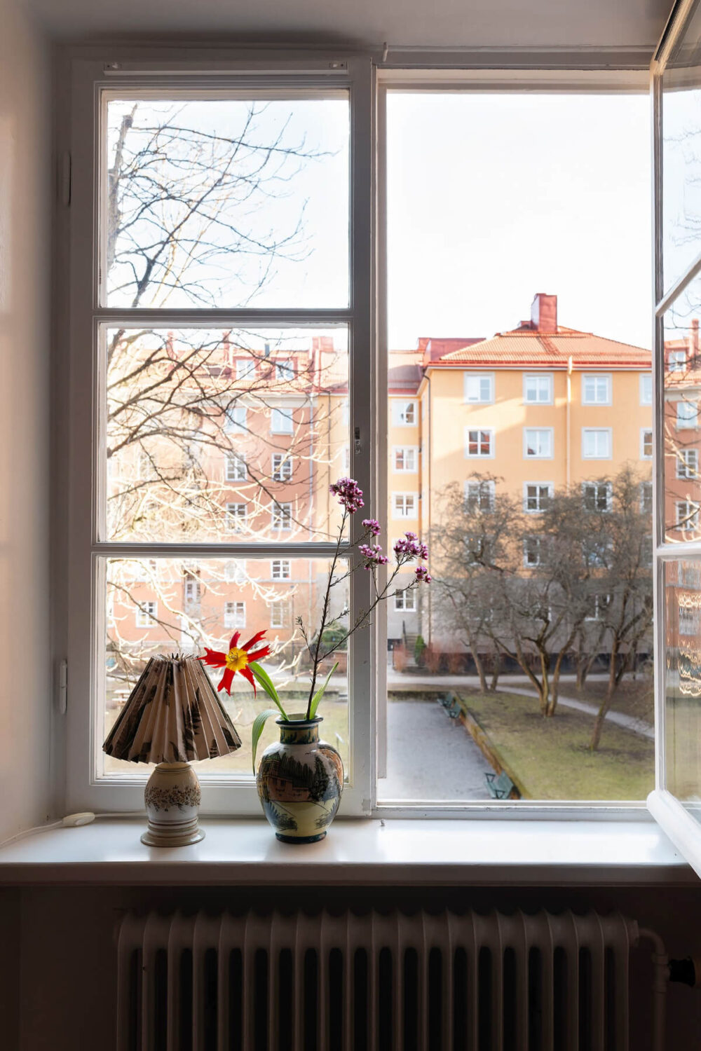 A Swedish Apartment with Period Features and Charming Color Pops 5 view from living room window