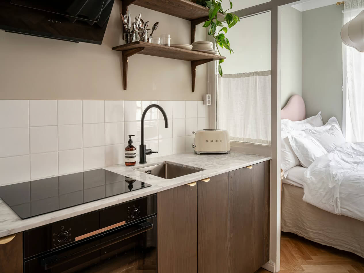 A Charming Small Apartment with a Cozy Bedroom Niche 10 walnut kitchen wood framed glass wall to bedroom
