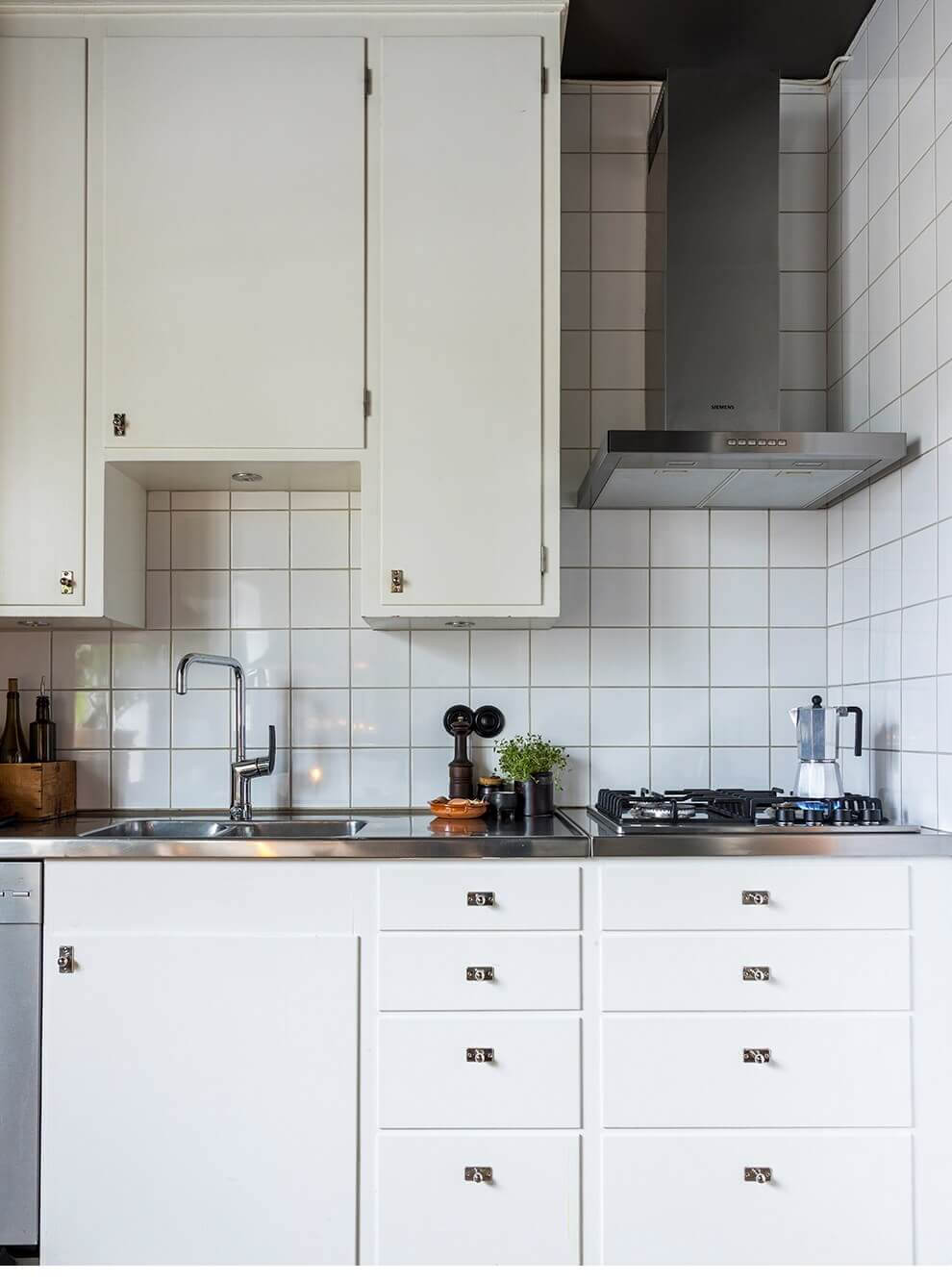 A Cozy Studio Apartment in a 1930s Building 12 white kitchen stainless steel countertop