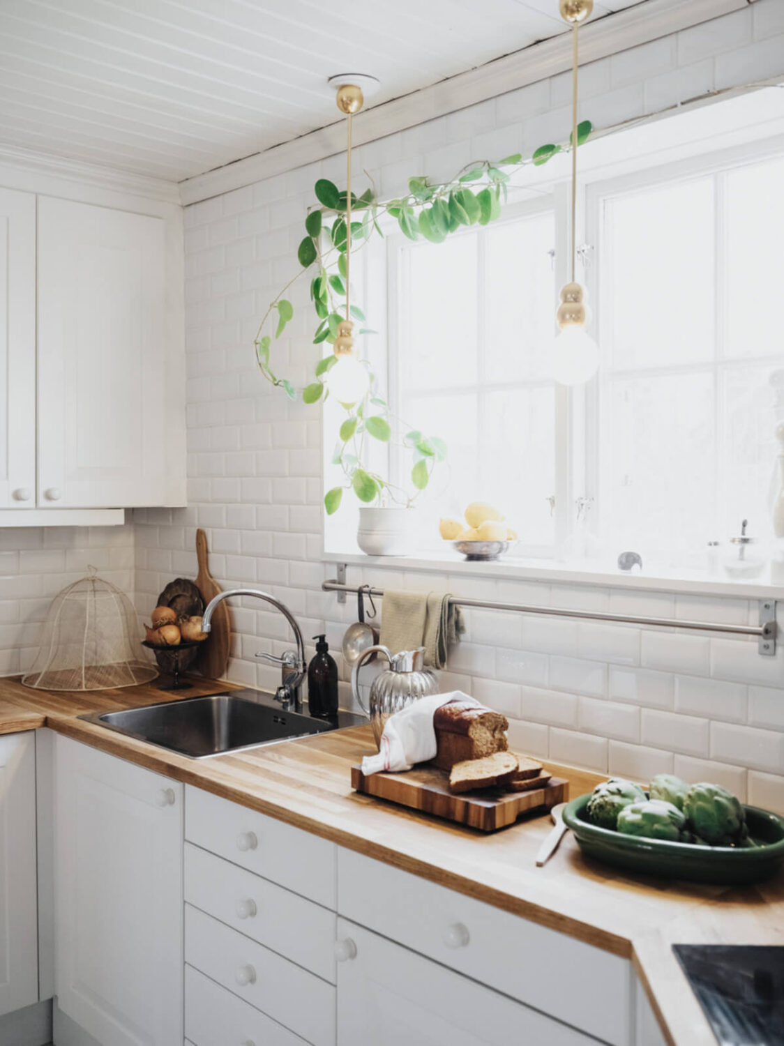 Light-Filled Rooms in a Charming 1907 Swedish Villa 18 white kitchen wooden countertop large window