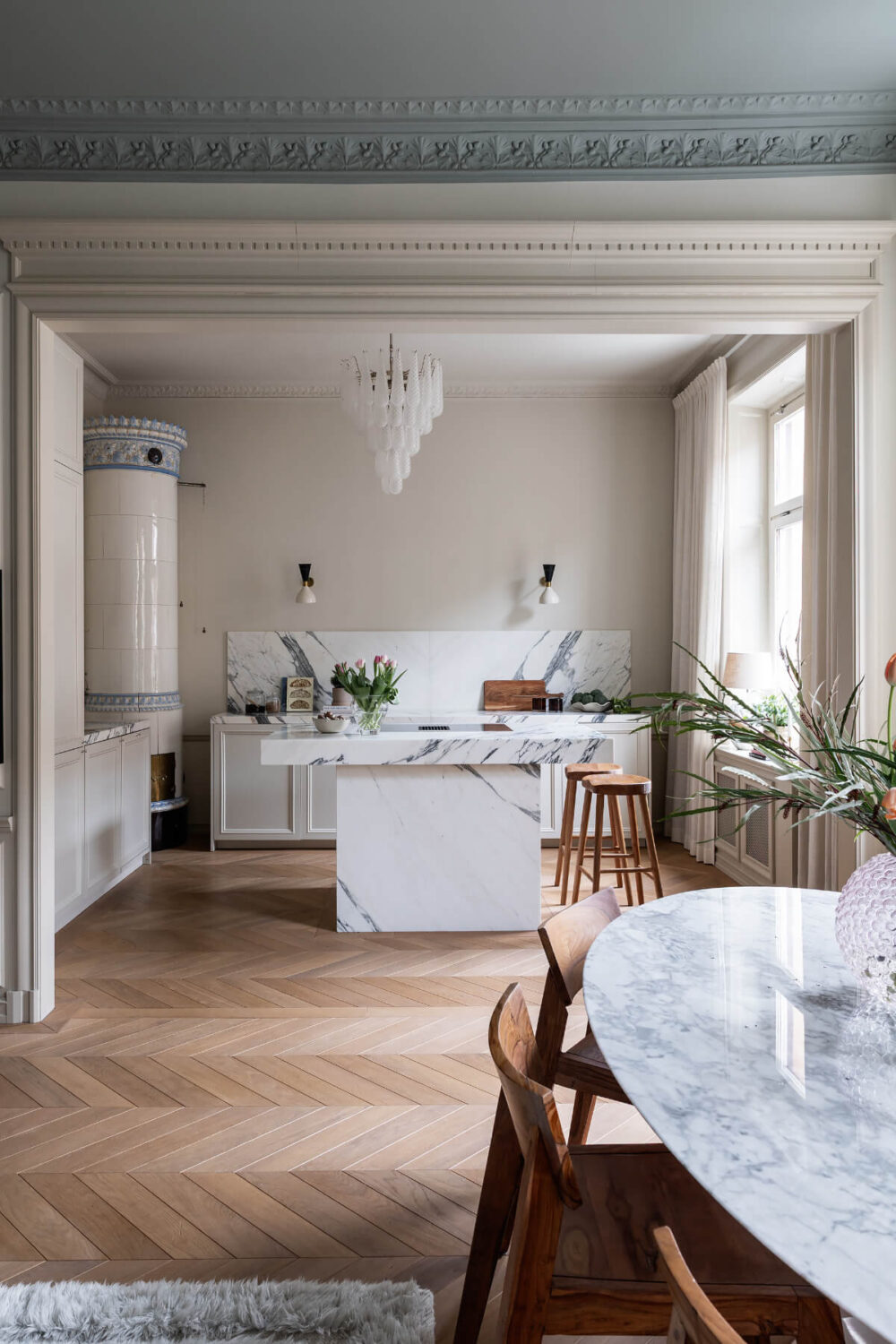 A Luxurious Stockholm Apartment with Period Features and a Blue Fireplace 8 wide doorway open plan living space chevron floor