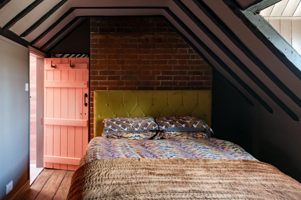 Colorful Design and Historic Features in a Charming English Home 23 attic bedroom wooden beams exposed brick wall nordroom
