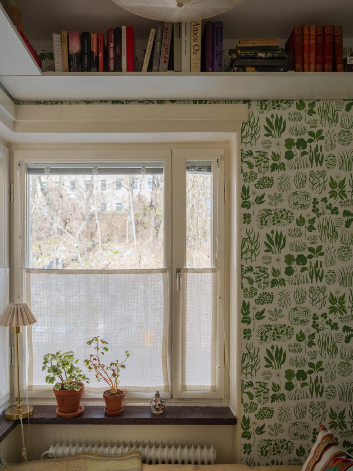 A Tiny Apartment Filled with Books and a Midcentury-Style Kitchen 23 bedroom window bookshelf