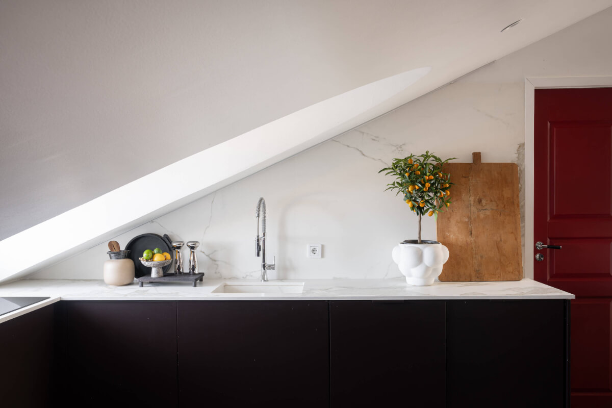 A Stylish Black and White Penthouse Apartment in Stockholm 10 black kitchen marble countertop slanted ceiling