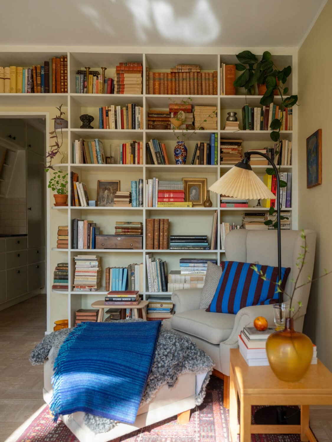 A Tiny Apartment Filled with Books and a Midcentury-Style Kitchen 2 cozy reading spot blue color accent