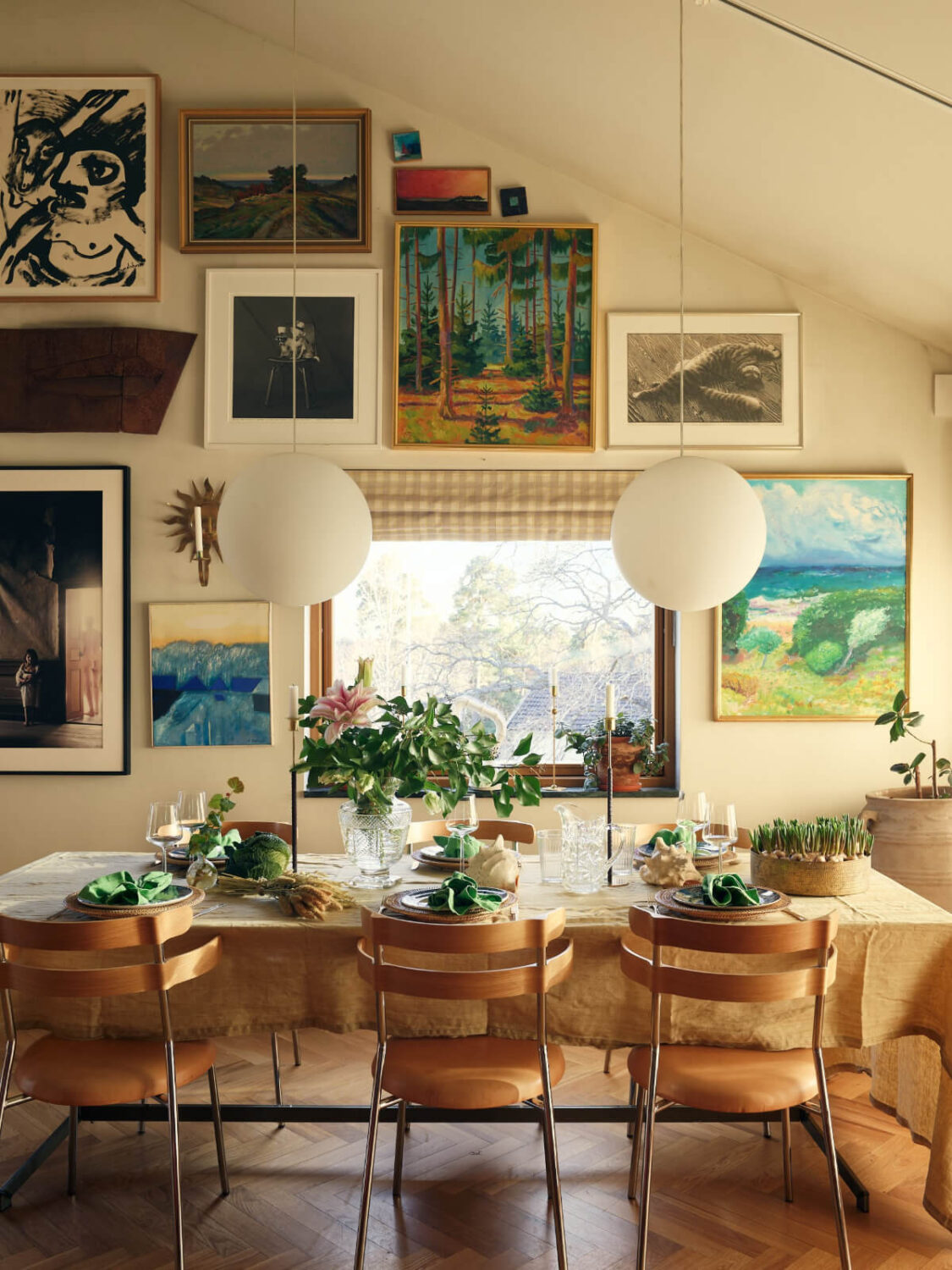 A Personal and Cozy 1960s Family Home in Sweden 3 dining table gallery wall pitched ceiling