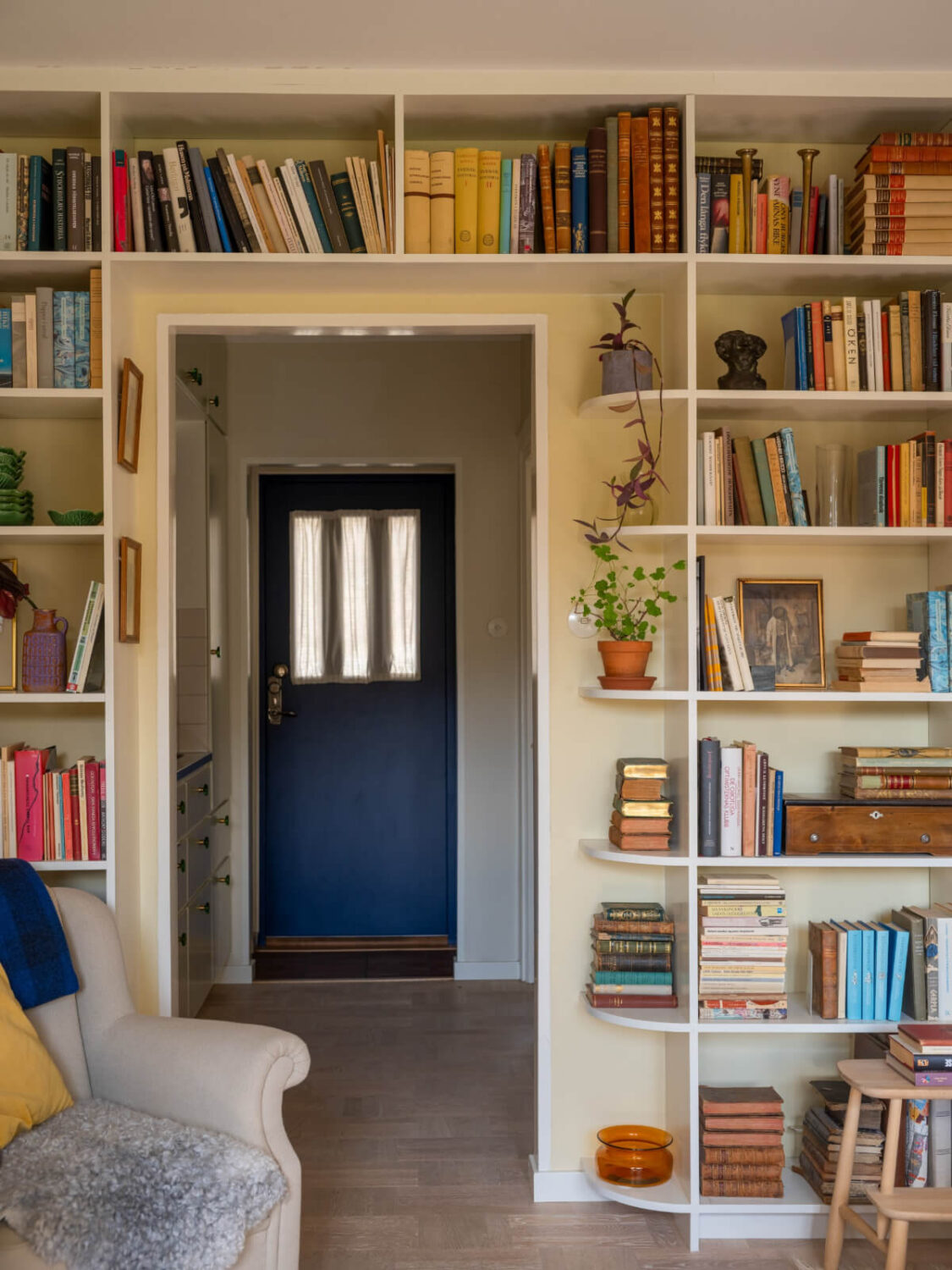 A Tiny Apartment Filled with Books and a Midcentury-Style Kitchen 14 doorway with bookshelves