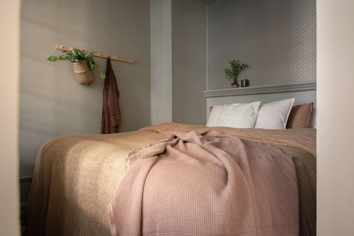 Warm Colors and Classic Elements in a Charming Studio Apartment 8 gray bedroom niche earthy and pink bedding