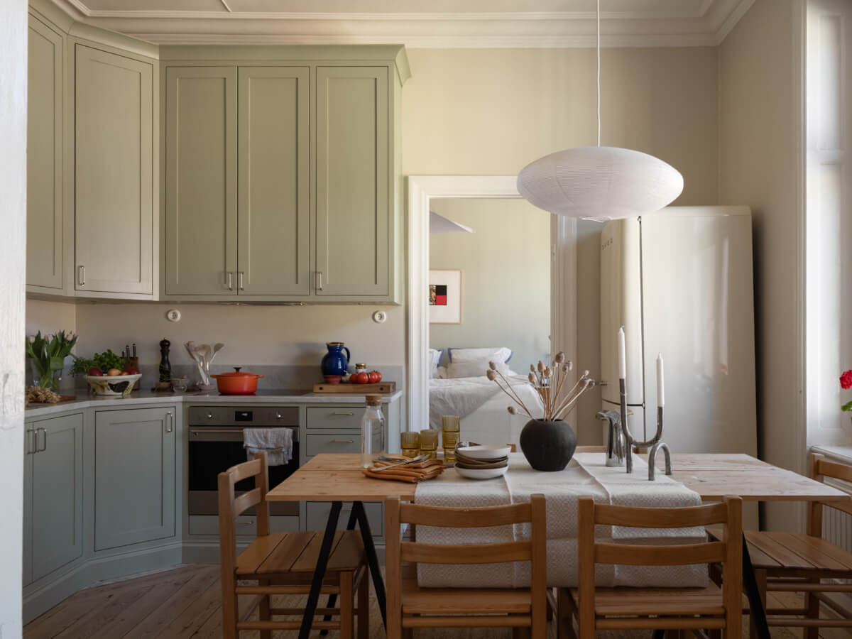 Turn-of-the-Century Charm and Site-Built Storage in a Stockholm Apartment 10 gray-green kitchen cabinets large rustic wooden dining table