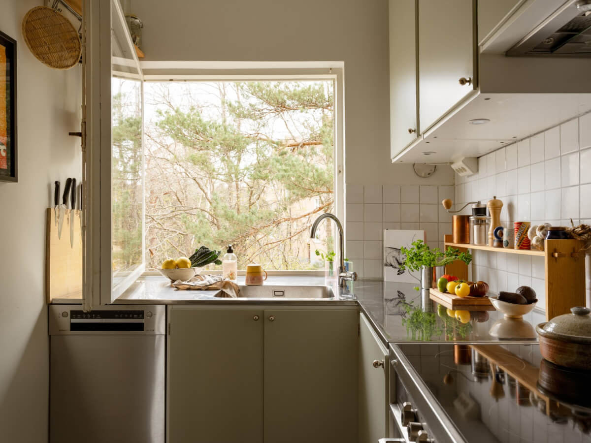 Color Accents in a Renovated Midcentury Apartment in Stockholm 16 green kitchen large window