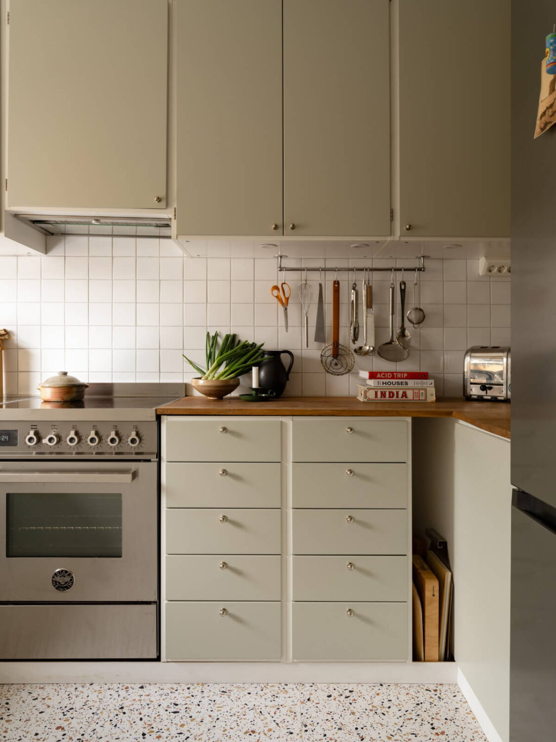 Color Accents in a Renovated Midcentury Apartment in Stockholm 13 green kitchen terrazzo floor