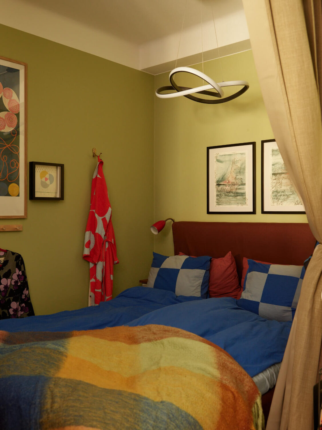 A Colorful Studio Apartment with Smart Storage and A Cozy Bed Niche 8 green studio bed nook with curtains