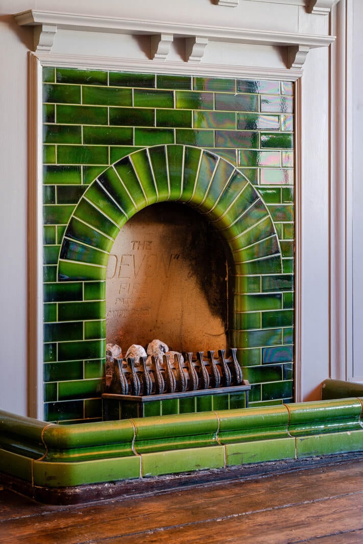 Colorful Design and Historic Features in a Charming English Home 19 green tiled fireplace nordroom
