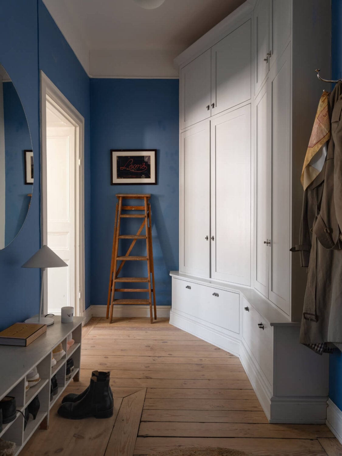 Turn-of-the-Century Charm and Site-Built Storage in a Stockholm Apartment 26 hall blue walls wooden floor built-in wardrobes