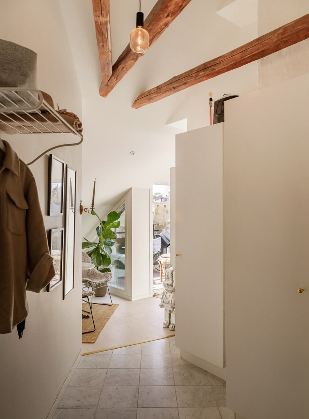 A Bright Attic Apartment with Exposed Beams and a Roof Terrace 23 hall marble tiles exposed wooden beams A Bright Attic Apartment with Exposed Beams and a Roof Terrace