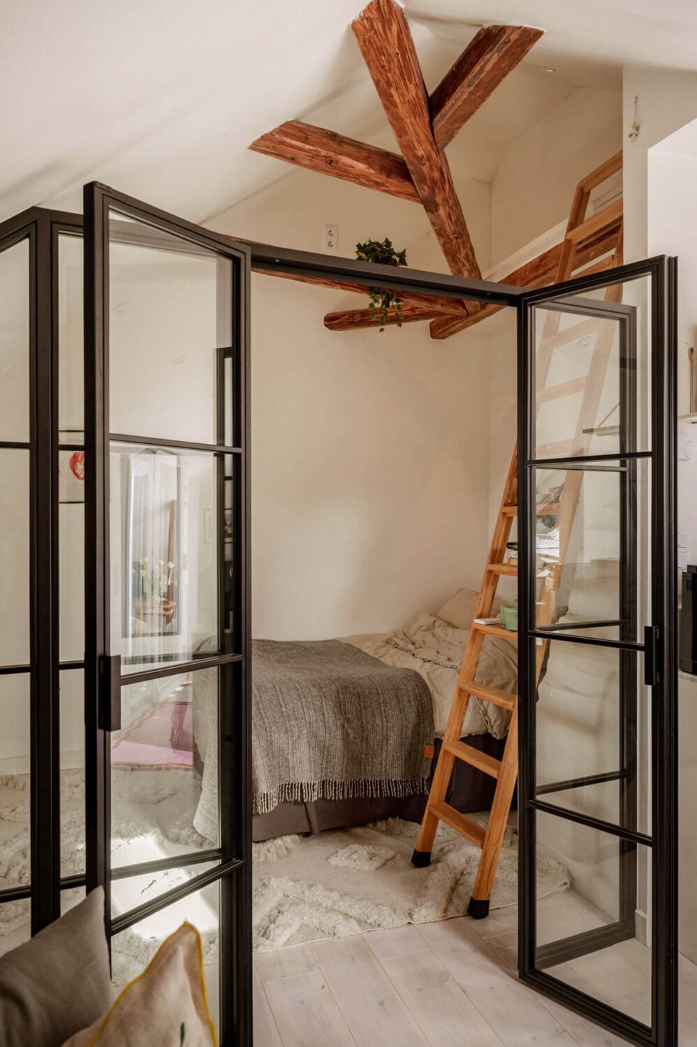 A Bright Attic Apartment with Exposed Beams and a Roof Terrace 13 industrial glass doors small bedroom