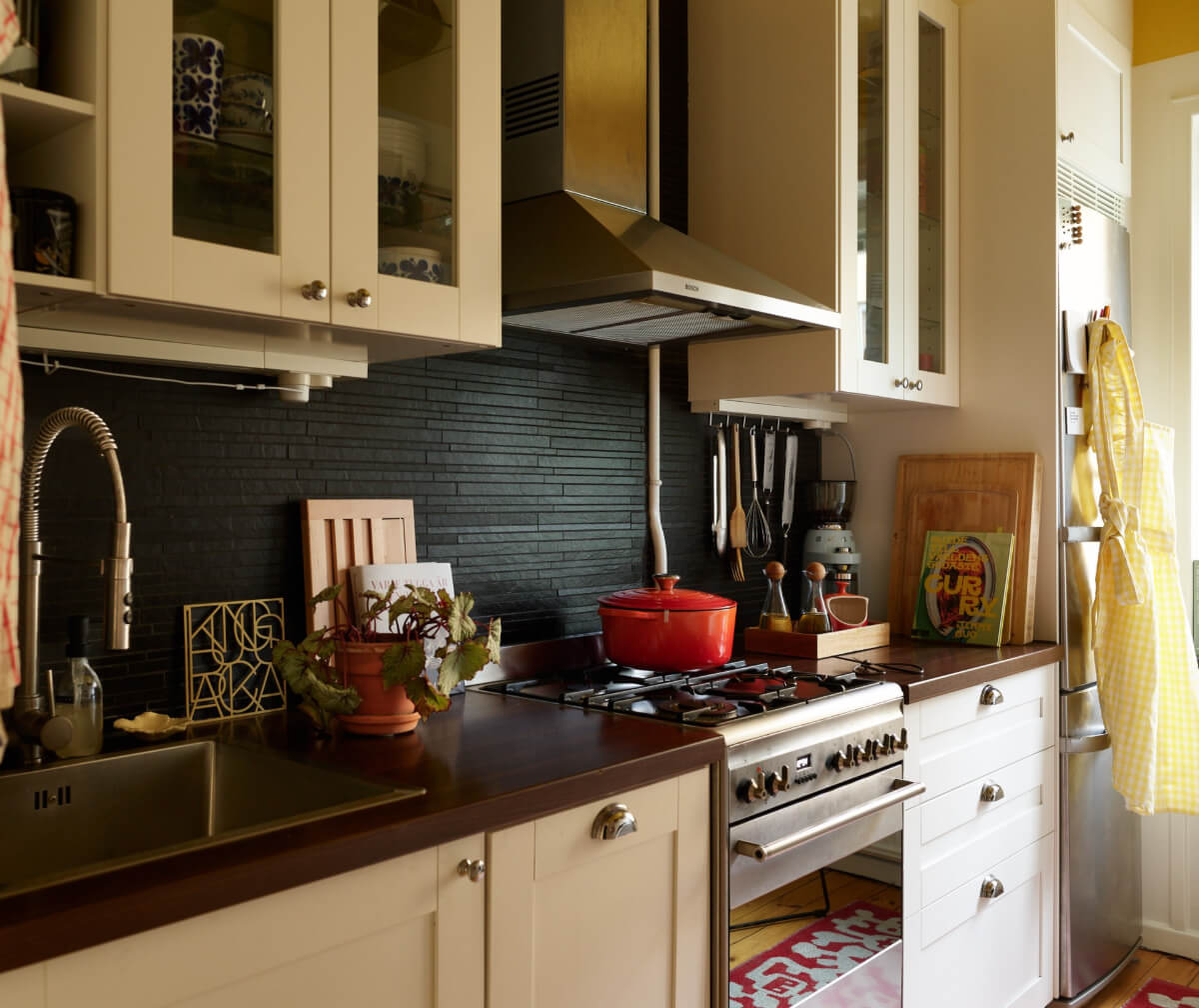 A Colorful Studio Apartment with Smart Storage and A Cozy Bed Niche 13 kitchen black tile backsplash yellow ceiling