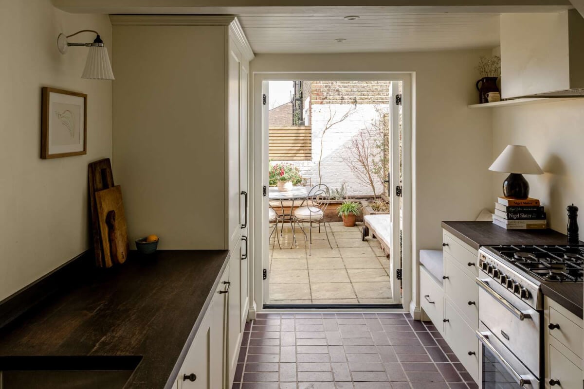 Reclaimed Materials and Custom Storage in a Serene London Home 11 kitchen glass doors to garden