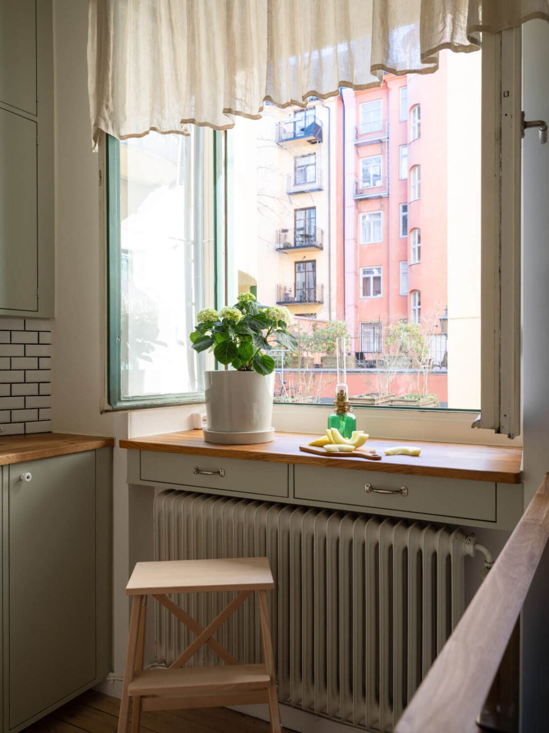 A Small Apartment with Green Color Accents and a Cozy Patio Terrace 19 kitchen window with drawers