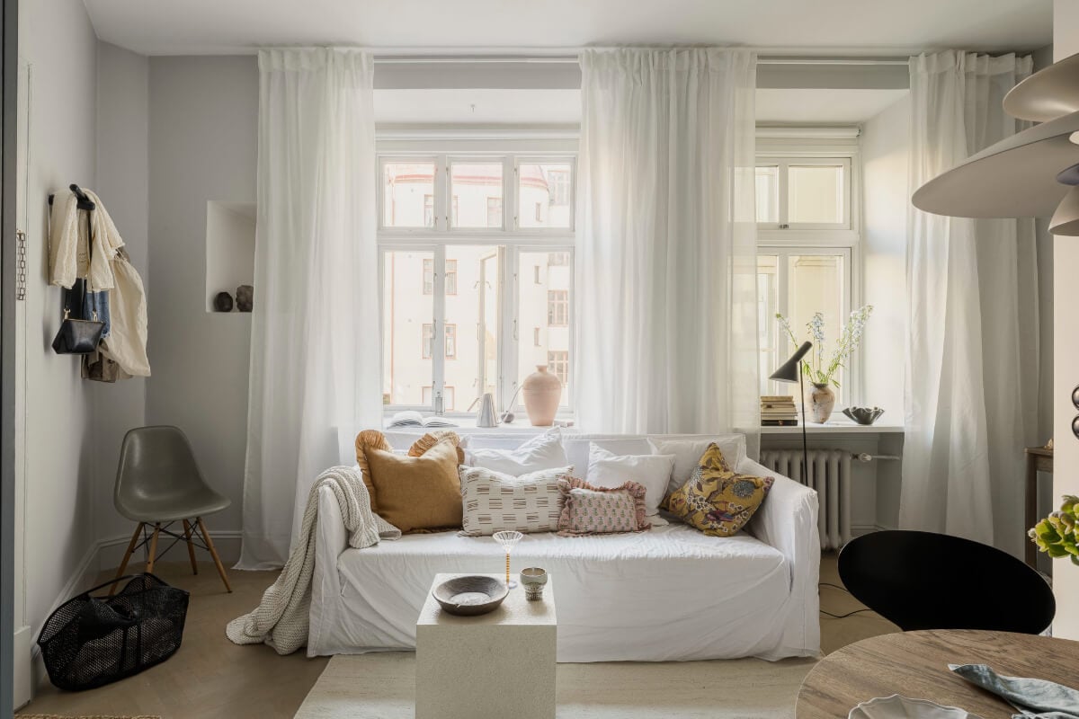 A Stylish Swedish Studio Apartment with a Blue Kitchen 7 light gray living room large window white sofa