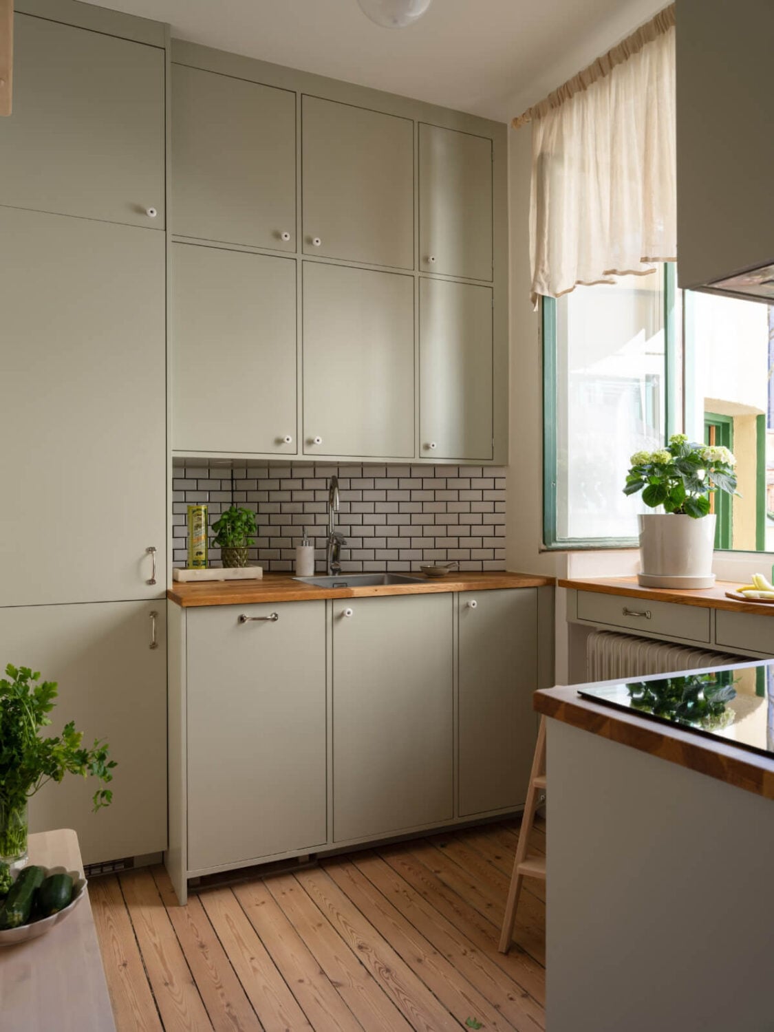 A Small Apartment with Green Color Accents and a Cozy Patio Terrace 18 light green kitchen white backsplash tiles