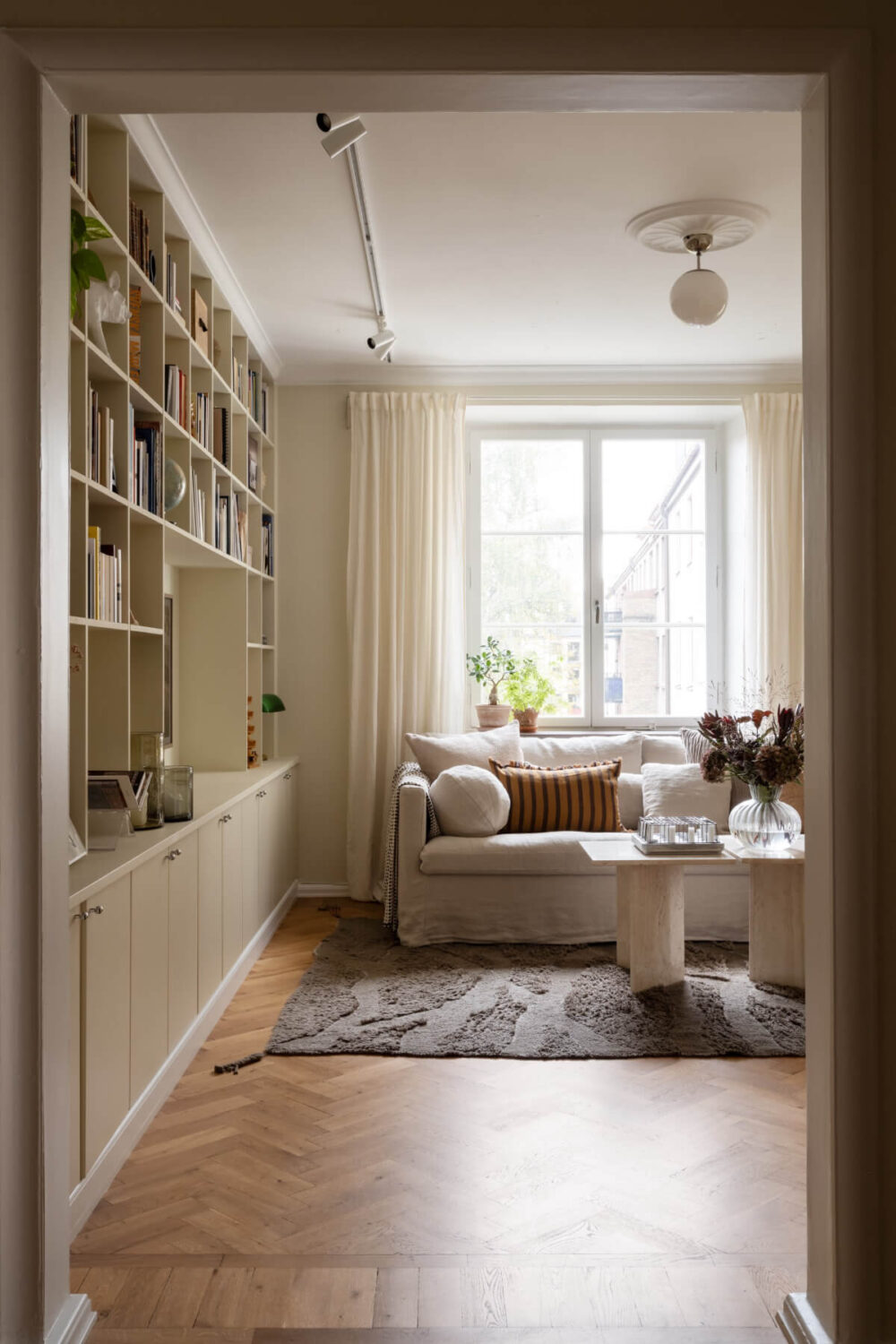 A Beige Color Palette and Built-in Bookshelves in a 1920s Apartment 3 living room parquet floor built-in bookshelves