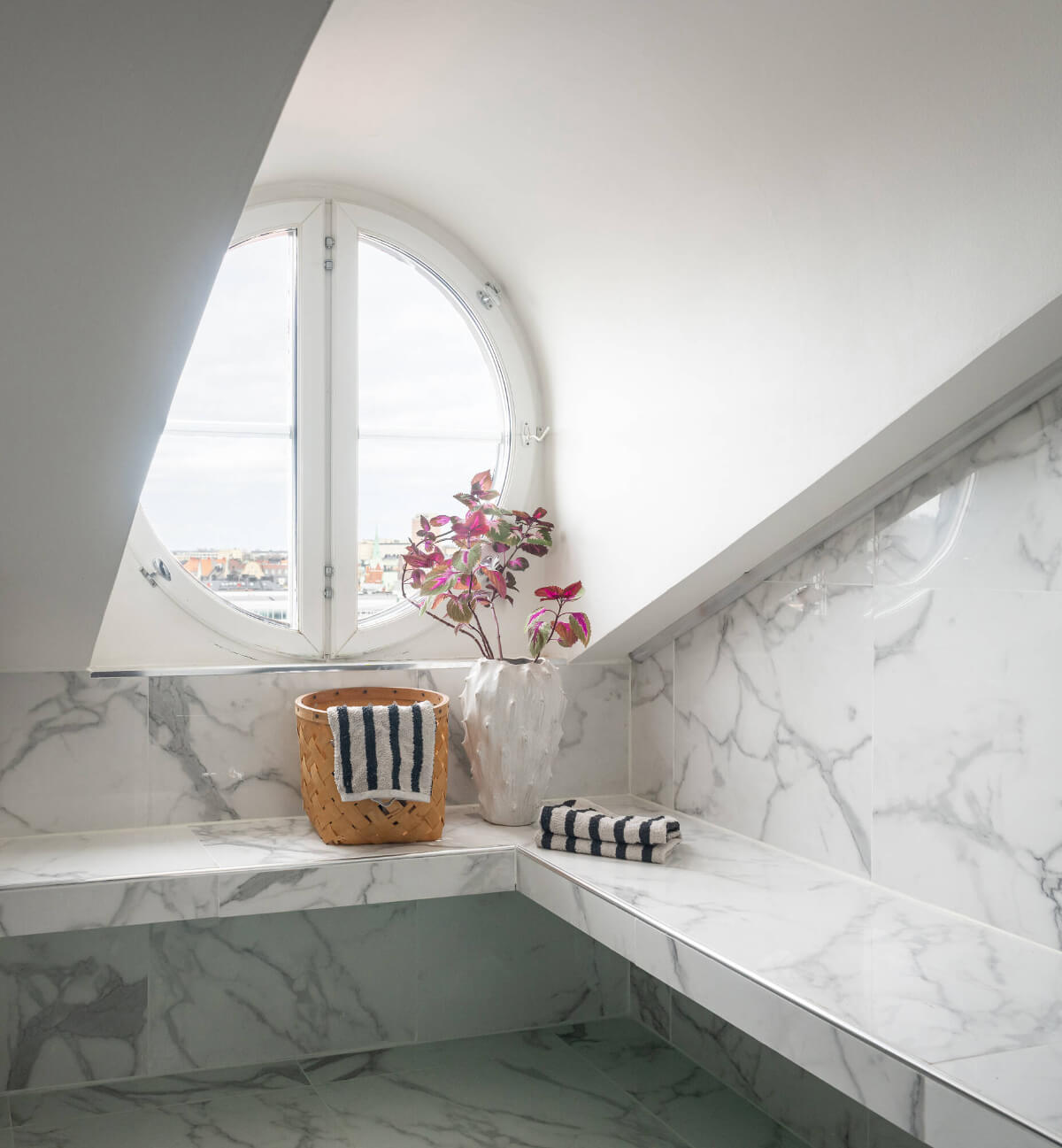 A Stylish Black and White Penthouse Apartment in Stockholm 18 marble bathroom round window A Stylish Black and White Penthouse Apartment in Stockholm