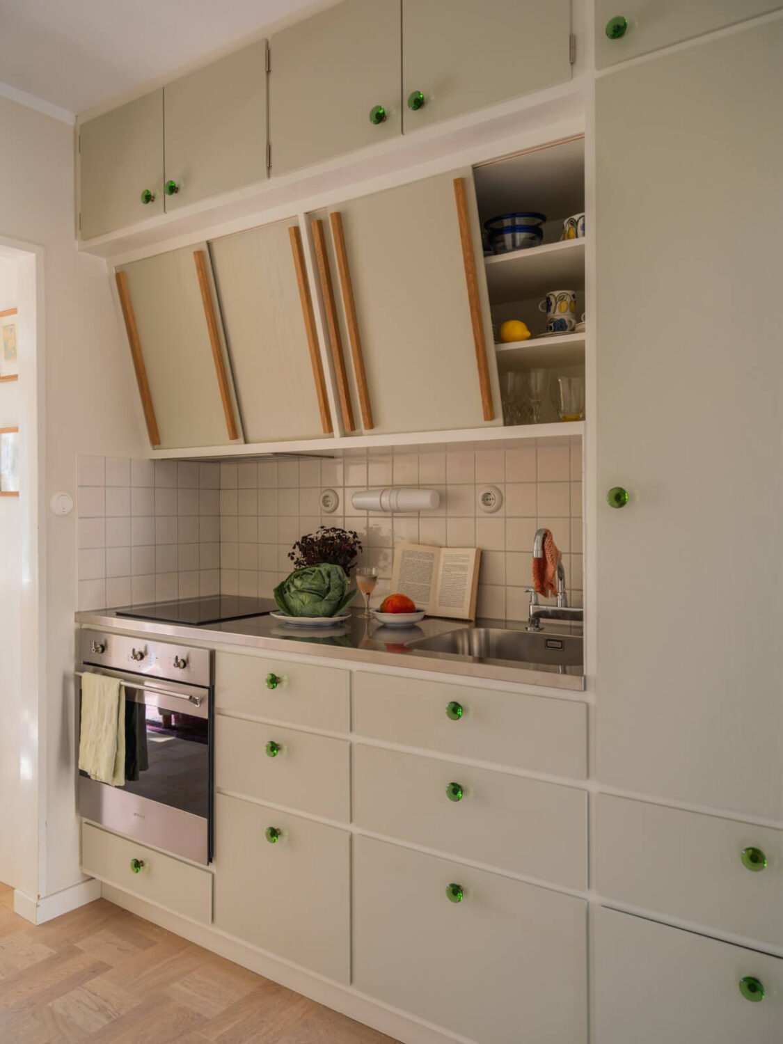 A Tiny Apartment Filled with Books and a Midcentury-Style Kitchen 17 midcentury kitchen green knobs