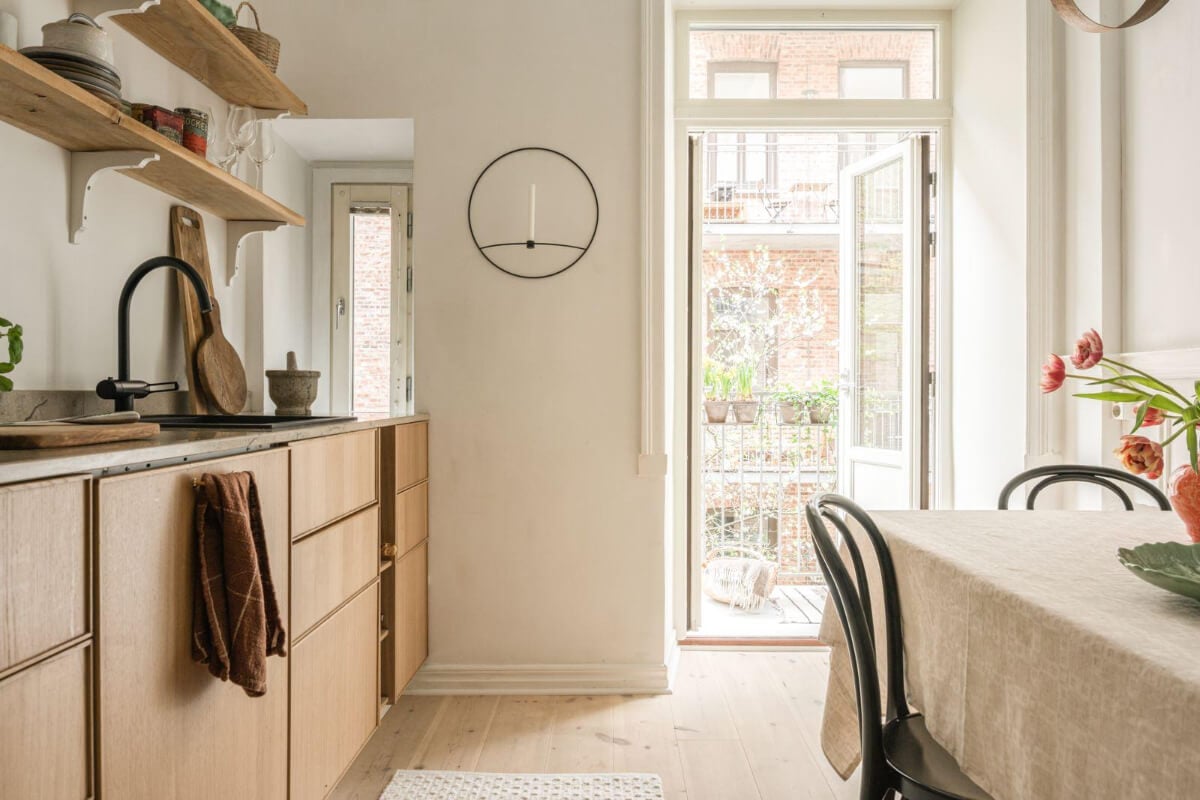 Warm Colors and Classic Elements in a Charming Studio Apartment 11 oak kitchen glass balcony doors