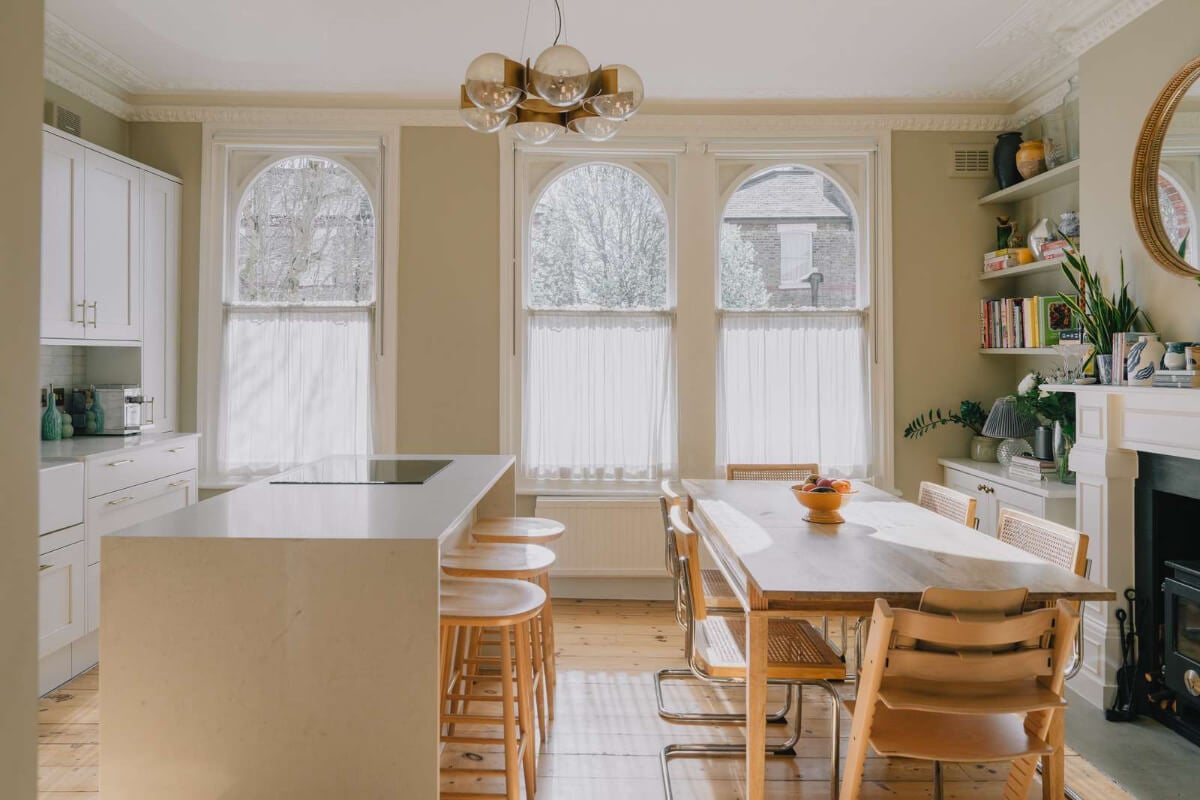 A Serene Color Palette and Built-In Shelves in a London Duplex 5 open plan kitchen dining area fireplace wooden floor