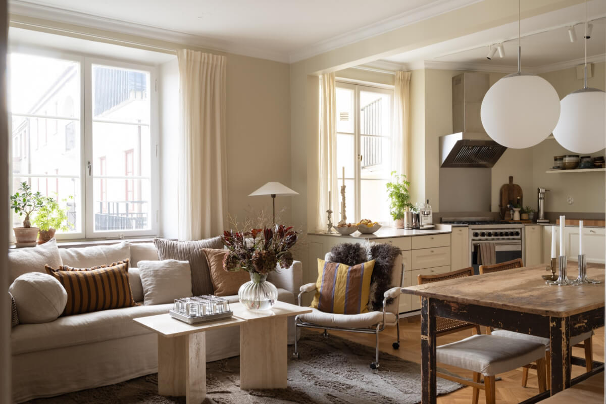 A Beige Color Palette and Built-in Bookshelves in a 1920s Apartment 5 open plan living room kitchen rustic dining table