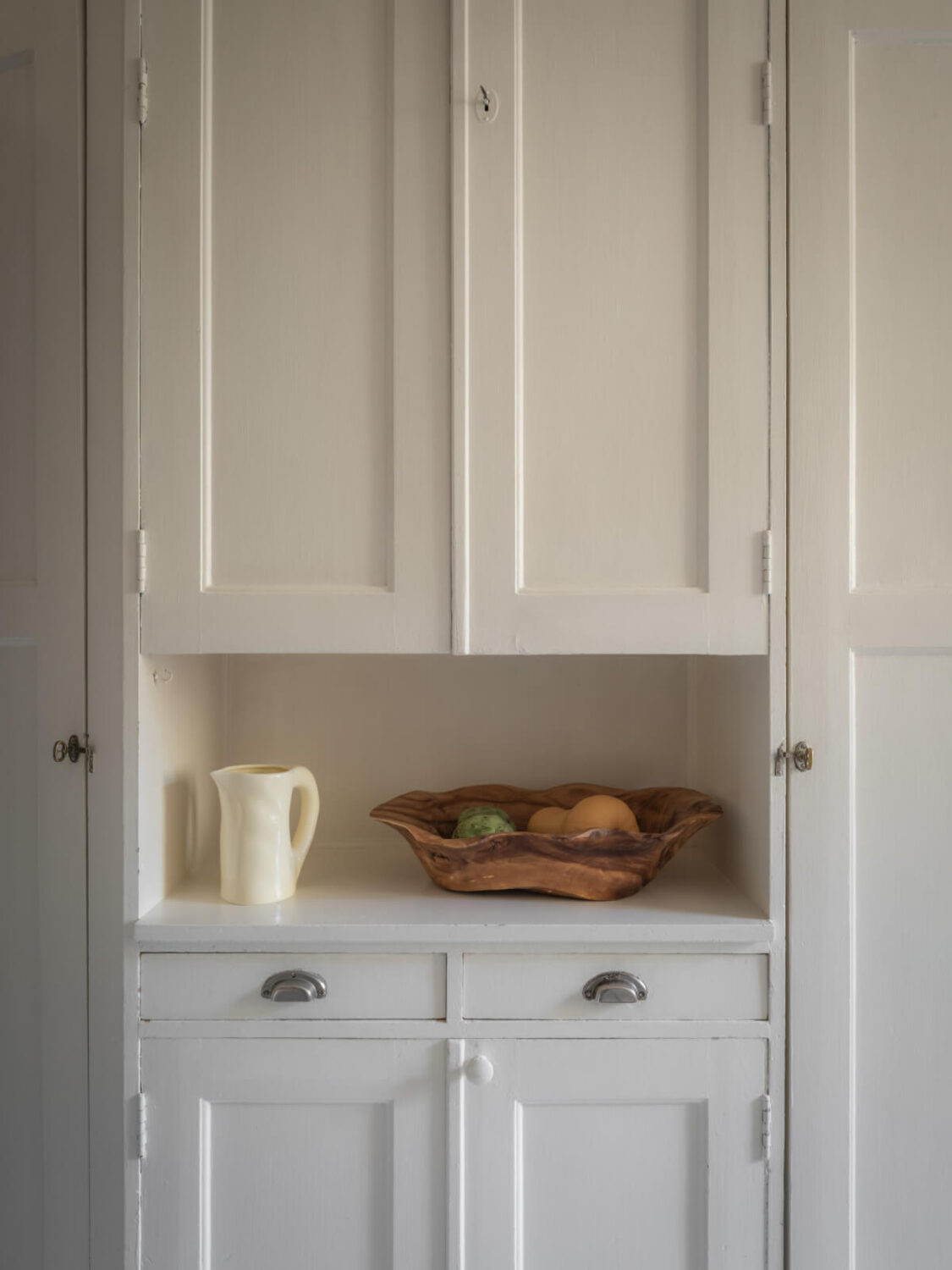 A Light-Colored Studio Apartment with a Cozy Kitchen 14 original pantry cabinet