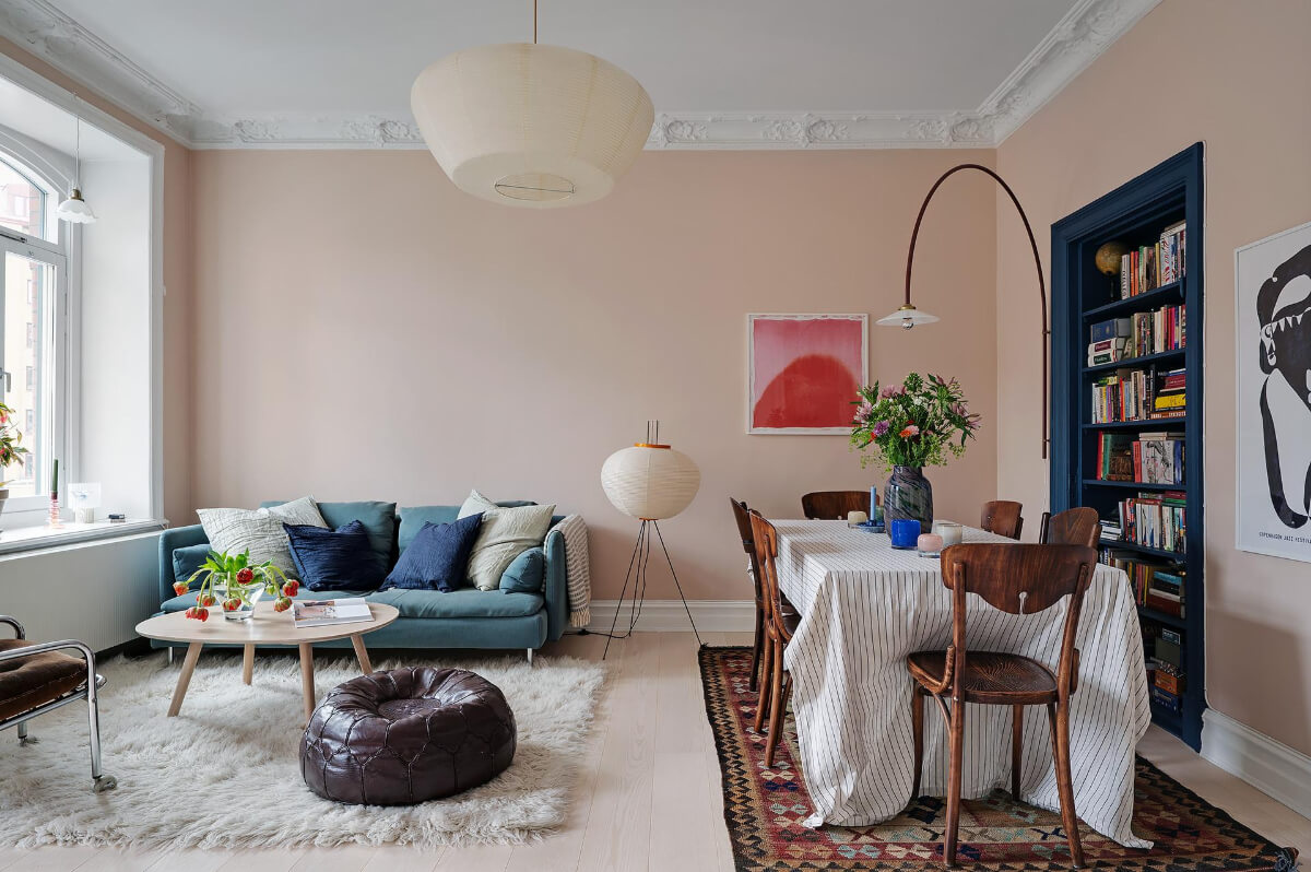 Pink and Blue Tones in a Late 19th-Century Apartment 1 pink living room wiht dining table blue-painted built-in bookcase