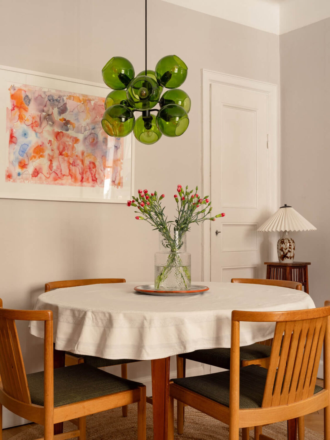 A Small, Cozy Apartment with Built-in Storage and Bookshelves 7 round dining table green pendant light