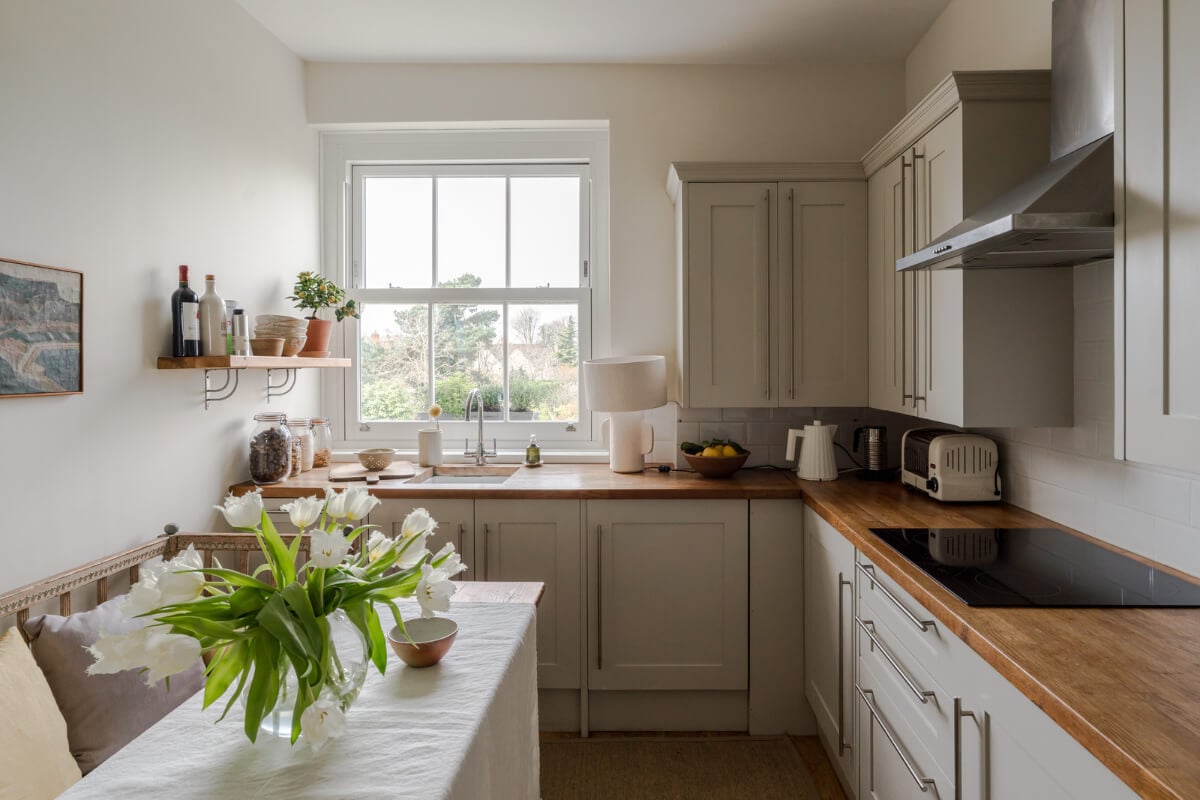 A Serene Color Palette and Arched Windows in a Small English Apartment 9 serene cottage style kitchen with dining table with bench