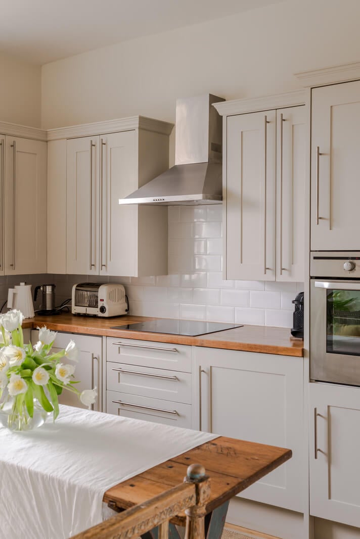 A Serene Color Palette and Arched Windows in a Small English Apartment 8 serene kitchen rustic wooden table